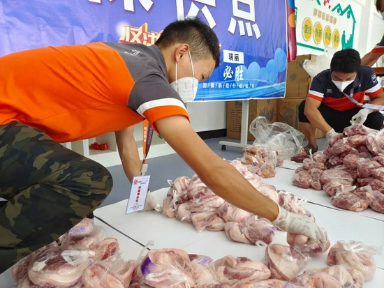 2021年7月10日，云南省瑞丽市的社区志愿者正在整理社区居民订购的肉类食品。